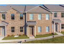Brick townhouse with 2-car garage and welcoming front porch at 3413 Hidden Stream Ct, Stockbridge, GA 30281