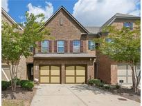 Brick townhouse with 2-car garage, and landscaping at 4430 Cedar Bridge Walk, Suwanee, GA 30024