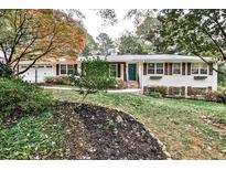 White brick ranch home with teal door, brown shutters, and landscaped yard at 496 Longview Dr, Norcross, GA 30071