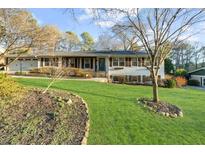 Charming one-story home featuring a well-maintained lawn and manicured landscaping at 496 Longview Dr, Norcross, GA 30071