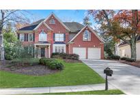 Brick two-story house with attached garage and landscaped lawn at 1215 Wynridge Xing, Alpharetta, GA 30005