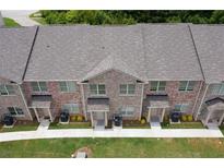 New brick townhomes featuring manicured lawn and professional landscaping at 3406 Mount Zion Rd, Stockbridge, GA 30281