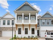 Two-story craftsman style home with gray and white exterior, two-car garage, and landscaped front yard at 89 Batten Board Way, Woodstock, GA 30189