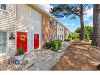 Charming townhomes with red front doors, brick and vinyl siding and neatly manicured landscaping at 1016 Old Holcomb Bridge Rd, Roswell, GA 30076