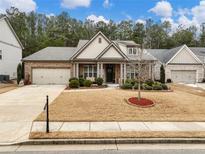 Brick house with 2-car garage, manicured lawn, and mature trees at 3578 Crayton Glen Way, Buford, GA 30519