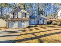 Charming two-story home featuring a two-car garage and manicured front lawn, nestled amongst tall trees at 3950 Fennel Sw Cir, Atlanta, GA 30331