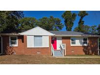 Brick ranch home with a red door, steps, and a well-manicured lawn at 1915 Campbellton Sw Rd, Atlanta, GA 30311