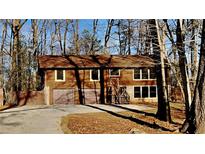Two-story house with attached two-car garage and wooded backdrop at 2395 River Run Dr, Douglasville, GA 30135