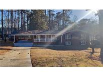 Brick ranch home with carport, landscaping, and large windows at 2644 Mayflower Rd, Atlanta, GA 30337