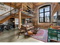 Spacious loft living area with exposed brick, high ceilings, and a modern aesthetic at 170 Boulevard Se # H-221, Atlanta, GA 30312