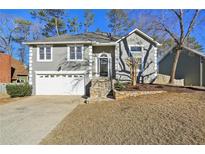 Two-story house with gray siding, stone accents, and a white garage door at 1020 Wellers Ct, Roswell, GA 30076