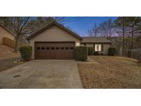 Tan house with brown garage door, driveway, and manicured bushes at 546 Paden Dr, Lawrenceville, GA 30044