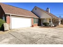 Brick ranch home with attached garage and landscaped yard at 12384 Riviera Dr, Fayetteville, GA 30215