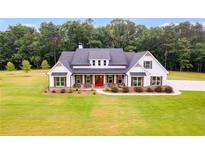 Two-story farmhouse with white exterior, red door, and large windows at 350 Taylor Path, Dallas, GA 30157