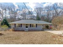 Ranch home with gray brick exterior, covered carport, and spacious yard at 3844 Davis St, Suwanee, GA 30024