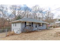 Charming grey brick home with classic design and inviting front yard landscape at 3844 Davis St, Suwanee, GA 30024
