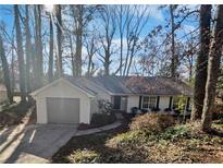 White ranch house with gray garage door and mature trees at 2268 Turtle Club Ne Dr, Marietta, GA 30066