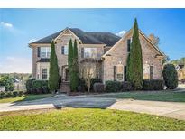 Charming two-story brick home featuring manicured landscaping and a welcoming front entrance at 4851 Planters Walk, Douglasville, GA 30135