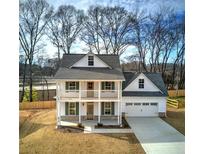 Two-story farmhouse with front porch, attached garage, and landscaped yard at 96 Rome St, Temple, GA 30179