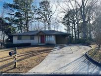 Ranch house with red door, driveway, and mature trees at 785 Jett Rd, Jonesboro, GA 30236