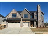 Beautiful two-story home featuring a brick and gray siding exterior and a large brick chimney at 4074 Hosch Retreat Dr, Buford, GA 30519