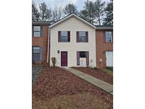 Two-story home featuring a beige facade, dark trim, and a walkway leading to the front door at 6002 Pat Mell Se Pl, Smyrna, GA 30080
