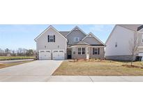 Two-story house with a three-car garage and landscaping at 13561 Whitman Ln, Covington, GA 30014