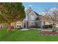 Charming two-story home featuring a manicured lawn, beautiful landscaping, and classic architectural details at 4497 Black Water Cv, Ellenwood, GA 30294