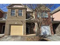 Brick townhouse exterior with a two-car garage and landscaping at 3551 Brycewood Dr, Decatur, GA 30034