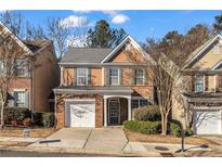 Charming two-story home with brick accents, manicured lawn, and attached one car garage at 1538 Park Grove Dr, Lawrenceville, GA 30046