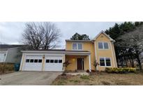 Cute yellow two-story house with a two-car garage at 2082 Montgomery Trl, Duluth, GA 30096