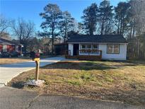 Newly renovated home with front porch and driveway at 1840 Judy Se Cir, Marietta, GA 30060