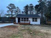 Newly renovated white house with a modern deck and driveway at 1840 Judy Se Cir, Marietta, GA 30060