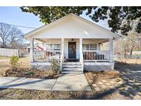 Charming white cottage with a spacious front porch at 3170 New Macland Rd, Powder Springs, GA 30127