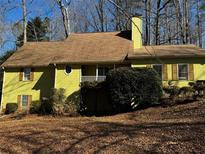 Charming yellow home with a brown roof, chimney, and a small porch at 5925 Tortosa Pl, Atlanta, GA 30349