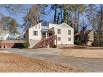 Inviting exterior of home featuring a wood deck and front yard with mature trees at 1775 Jody Ne Dr, Marietta, GA 30066