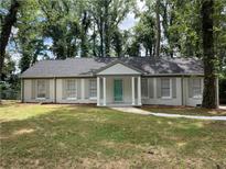 Charming ranch home with gray brick exterior, updated landscaping, and a welcoming front porch at 2812 Arlington Rd, Atlanta, GA 30344