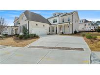 A charming two-story home with a three car garage, brick accents and manicured front yard landscaping at 11335 Bennett Ln, Johns Creek, GA 30097