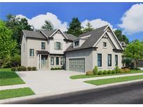 Two-story house with light brick exterior, green garage doors, and landscaping at 11335 Bennett Ln, Johns Creek, GA 30097