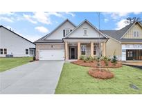Charming home featuring a brick facade, inviting front porch, and a well-manicured lawn at 161 Mooney Rd, Woodstock, GA 30188
