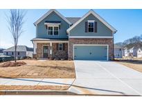 Charming two-story home with blue siding, brick accents, and a two-car garage, set against a clear sky at 1700 Fulmont Cir, Mableton, GA 30126