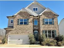Brick two-story house with a three-car garage and landscaped yard at 416 Aristides Way, Canton, GA 30115