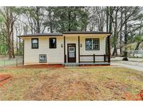 Charming home featuring a cozy front porch, neutral siding, and freshly mulched front yard at 6454 Boca Grande Blvd, Forest Park, GA 30297