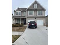 Two-story house with gray siding, two-car garage, and a landscaped front yard at 2398 Ticonic Rd, Lithonia, GA 30058