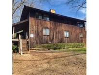 Exterior shot of a two-story cabin-style home with wood siding and a stairway leading to a small porch at 7 Quail Run, Decatur, GA 30035