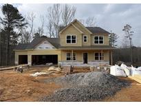Charming two-story home featuring a front porch, attached two-car garage, and undergoing construction at 1064 Cottonwood Ln, Loganville, GA 30052