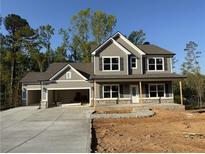 Charming two-story home with a welcoming front porch, attached two car garage, and manicured lawn at 1064 Cottonwood Ln, Loganville, GA 30052