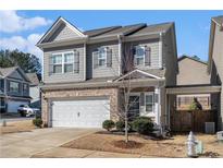 Two-story house with gray siding, white garage door, and landscaping at 202 Bryon Ln, Acworth, GA 30102