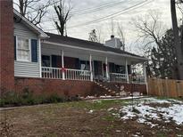 Charming brick home featuring a covered front porch with white railings and dark shutters at 2615 Leeshire Ct # 1, Tucker, GA 30084