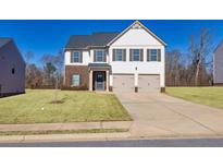 Two-story home with brick and siding exterior, two-car garage, and landscaped lawn at 98 Sandy Creek Dr, Covington, GA 30014